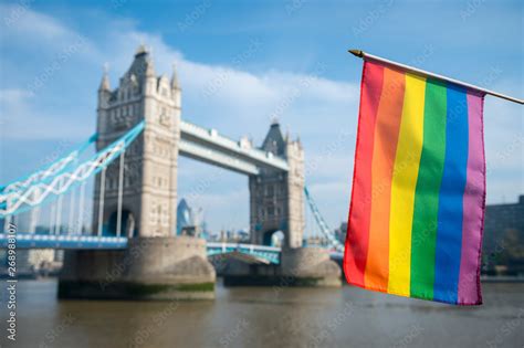 Gay Pride Rainbow Flag Hanging In Front Of The London Skyline At Tower Bridge On A Bright Sunny