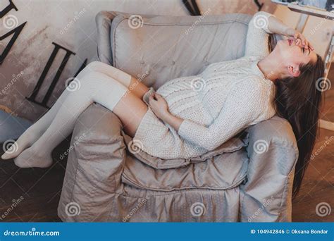Pregnant Brunette Girl In A White Knitted Sweater Lying In Armchair Stock Photo Image Of