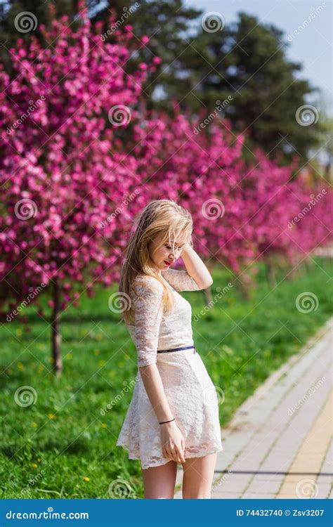 Belle Fille Blonde Avec De Longues Boucles Onduleuses Dans Une Promenade Blanche De Robe En Parc