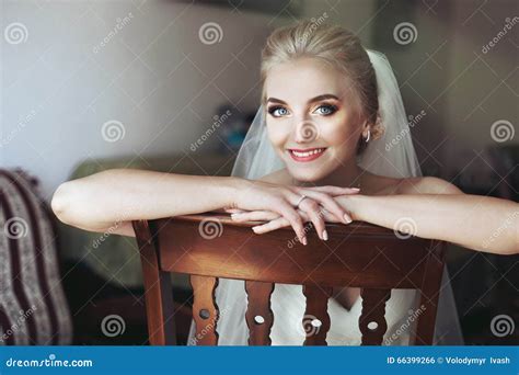 Gorgeous Innocent Blonde Bride Posing While Sitting On Wooden Ch Stock Photo Image Of