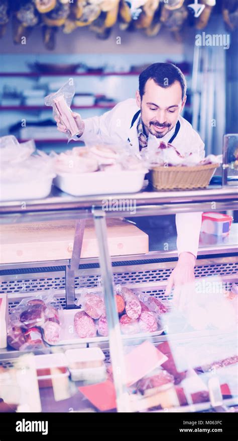 Positive Russian Male Shop Assistant Demonstrating Sliced Bacon In