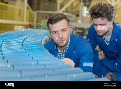 Engineers Looking At Rolling Conveyor Belt In Factory Stock Photo Alamy