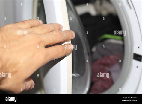 Mans Hand Puts Things In The Washing Machine Stock Photo Alamy