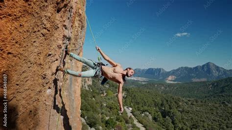 Strong And Muscular Fit Rock Climber Hangs On Rope On Vertical Cliff Handsome Man With Naked