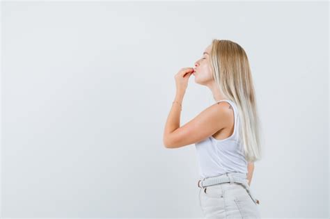 Blonde Dame Im Unterhemd Hose Zeigt K Stliche Geste Und Sieht Entz Ckt Aus Kostenlose Foto