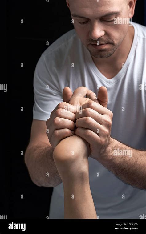 Male Masseur Hands Doing Reflexology Massage On Female Foot Reflex Zones In The Spa Salon Stock