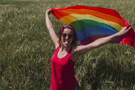 Woman Holding The Gay Rainbow Flag On A Green Meadow Outdoors Happiness Freedom And Love