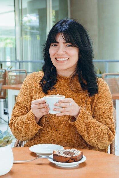 Retrato De Una Joven Latina Sentada Sonriendo Mirando A La C Mara Mientras Desayuna En Una