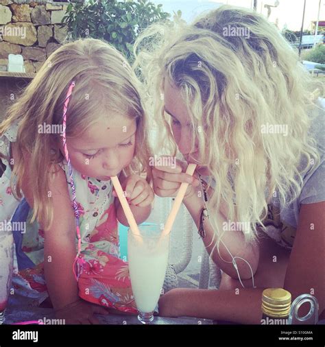Zwei blonde Mädchen teilen einen Milchshake mit Zöpfen in den Haaren Stockfotografie Alamy