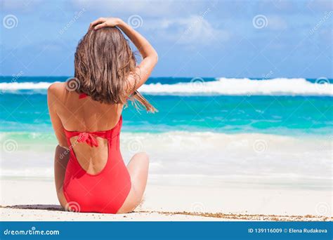 Retrato De La Mujer De Pelo Largo En Bikini Rojo Y Las Gafas De Sol Que Mienten En La Playa