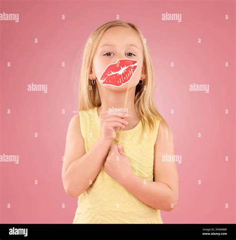 Portrait, children and lips with a girl on a pink background in studio ...