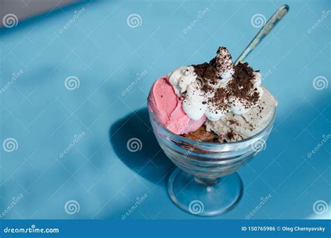 Various Colorful Ice Cream With A Spoon In Glass Bowl On Blue Table