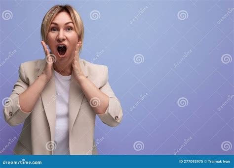 Blonde Surprise Jeune Adulte En Veste Avec Bouche Ouverte Sur Fond Studio Avec Espace Copie