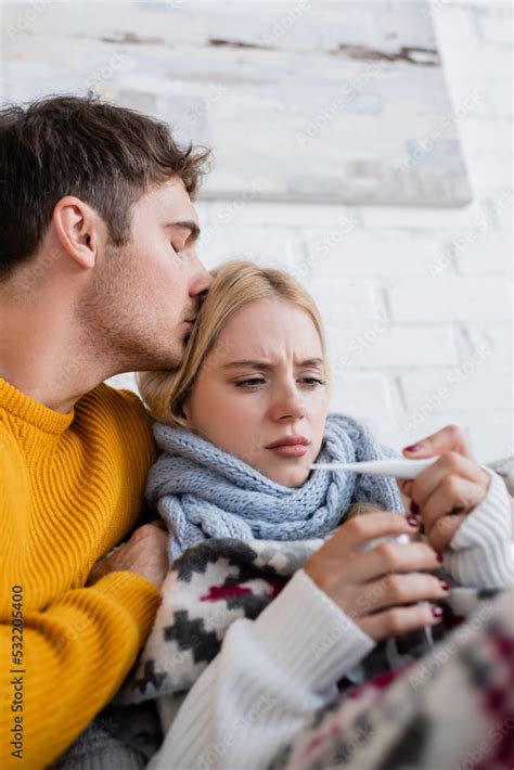 Caring Man Hugging And Kissing Head Of Sick Blonde Woman With Digital