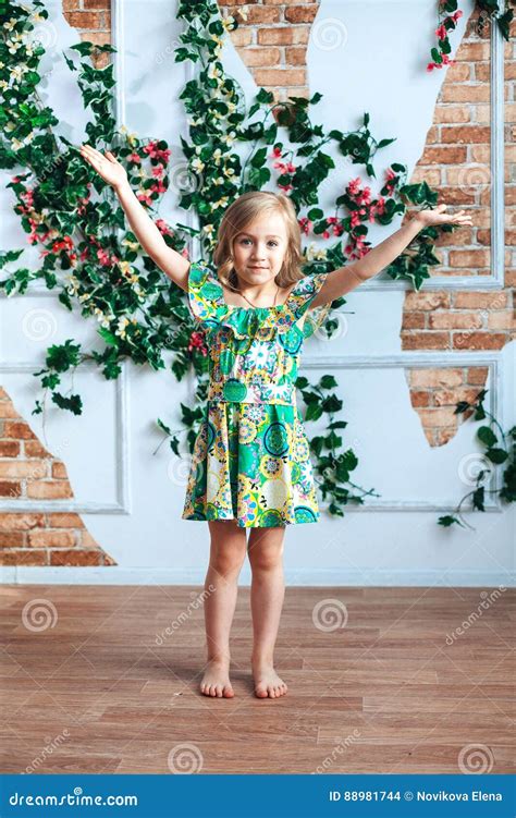 Une Petite Fille Blonde Dans Une Robe Lumineuse A Soulev Ses Bras Dans Une Chambre D Cor E Des
