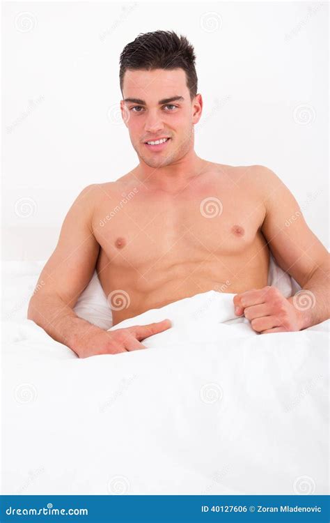 Proud Attractive Man Lying In Bed With Naked Torso Smiling Stock Photography CartoonDealer