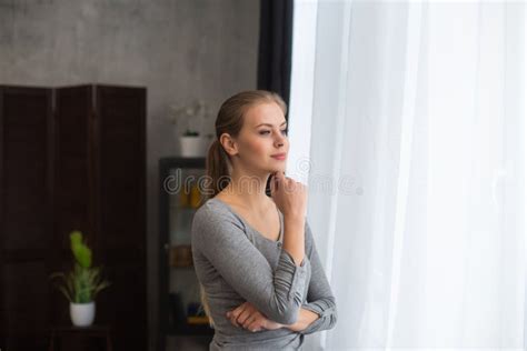Junges Teenager Steht Vor Dem Fenster Und Sieht Es An Blonde Frau Zu Hause Stockbild Bild