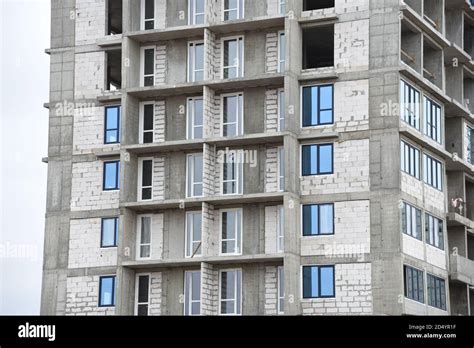 Installation of double-glazed windows in a multi-storey building at a construction site. Glazed ...