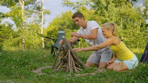 CLOSE UP Smiling Blonde Woman And Her Boyfriend Preparing A Campfire Together Stock Image