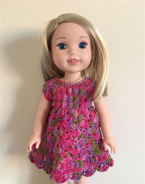 A Doll With Blonde Hair Wearing A Pink Crocheted Dress