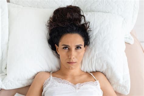 Premium Photo Sad Angry Millennial Caucasian Lady Brunette Wake Up Lies On Soft Bed Looks Up