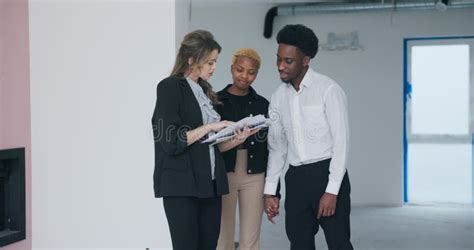 With Contract And House Plan In Hand The Confident Blonde Real Estate Agent Guides The Excited