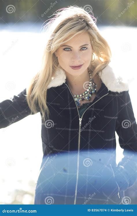Eine Herrliche Blonde Frau Mit Dem Durchbohren Von Blauen Augen Und Von Marineplaidwinterjacke