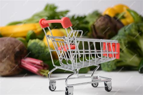 Тележка для покупок и различные свежие фрукты и овощи для макета ...