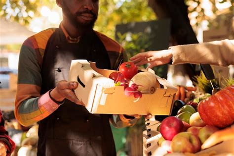 Granjero Afroamericano Que Da Una Caja Llena De Verduras Frescas A Una