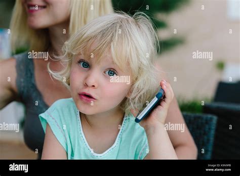 Petite Fille Blonde Assise Sur Les Genoux De Sa M Re Et De Jouer Avec Un Smartphone Photo Stock