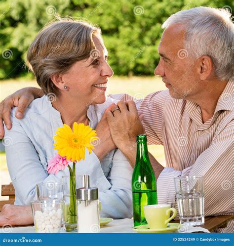 Retired Couple Sitting at Table Holding Hands Stock Image - Image of