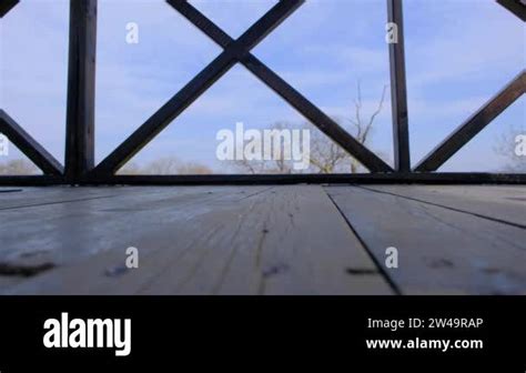 A Single Man On The Bird Watching Tower And Walking With Naked Foot And Wearing Blue Jeans And