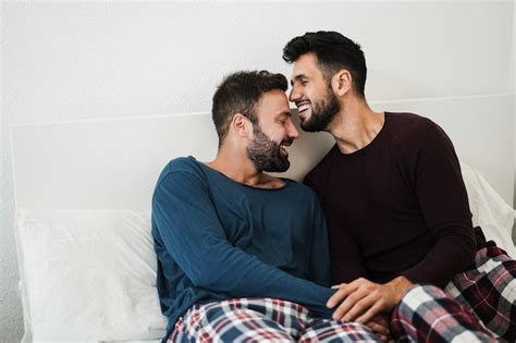 Pareja Gay Joven Que Tiene Un Momento Tierno En La Cama En Casa Centrarse En Las Caras Foto