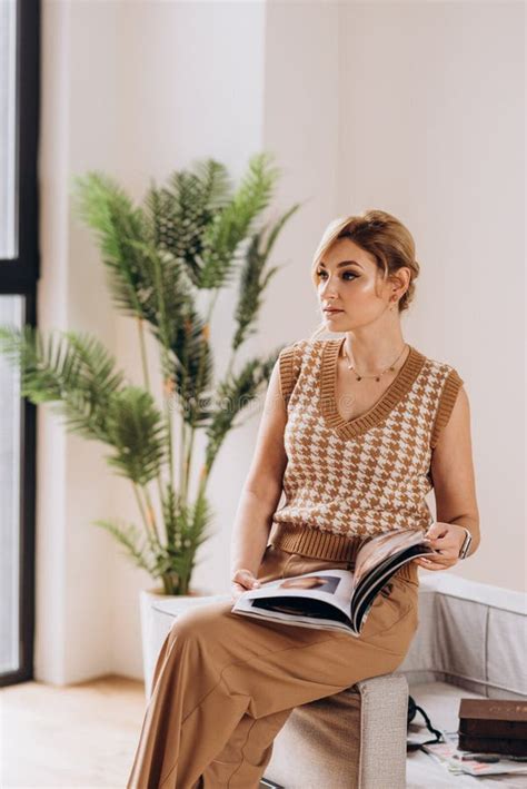 Stylish Blonde Woman In Nude Clothes Reads A Fashion Magazine Soft Selective Focus Artistic