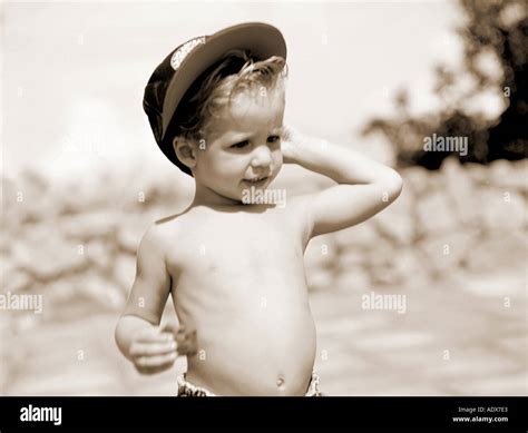 Enfants petit garçon torse nu cap holding cookie blonde ventre bras soulevé réfléchie derrière