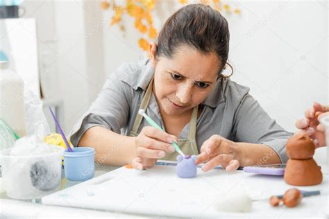 Mujer hispana trabajando en su pastelería Mujer latina trabajando con fondant para decorar un