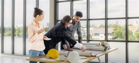 Engineer Team Meeting To Inspect the Construction Blueprint Drawings