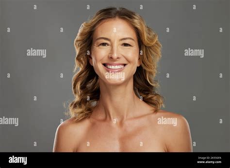 Visage beauté et soin de la peau avec une femme mature en studio sur fond gris pour le bien