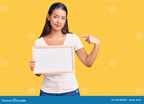 Jovem Linda Latina Segurando Um Quadro Branco Vazio Apontando O Dedo Para Um Autosorrindo Feliz