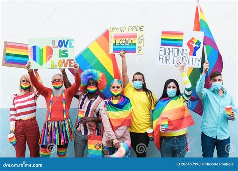 Multiracial Gay People With Rainbow Mask At Lgbt Pride Parade Outdoors Focus On Faces Stock
