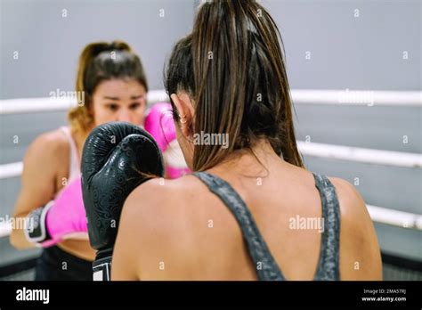 Unrecognizable Brunette Woman In Guard Position Practicing Boxing With Her Partner In The Ring