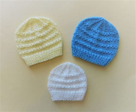 Three Knitted Hats Sitting Next To Each Other