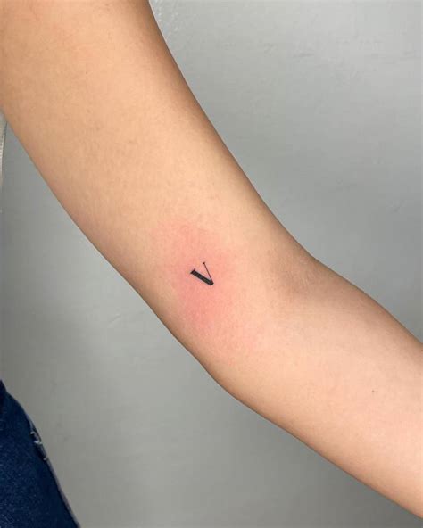 Minimalistic Tattoo Of The Letter V Located On The