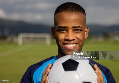 Pemain Sepak Bola Yang Bahagia Memegang Bola Sepak Dan Tersenyum Foto