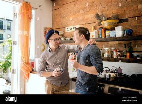 Gay Couple Standing Against Kitchen Counter At Home Stock Photo Alamy
