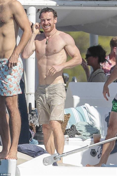 Two Men Standing On The Deck Of A Boat One Talking On His Cell Phone