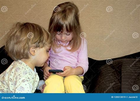 Kleine Nette Neugierige Blonde Zwillinge Passen Karikaturen Auf Smartphone Auf Stockbild Bild