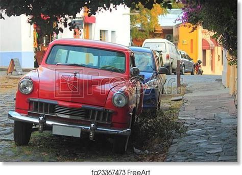 An Old Red Car Is Parked On The Street