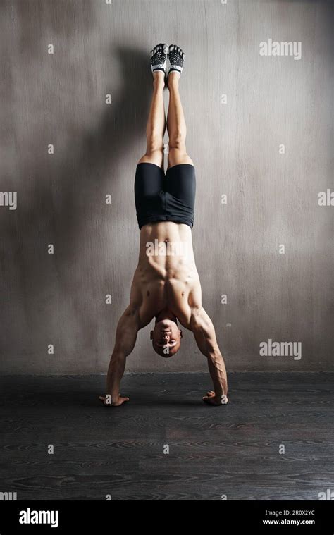 Cuerpo De La Aptitud La Pared Y El Hombre Haciendo Handstand Para El