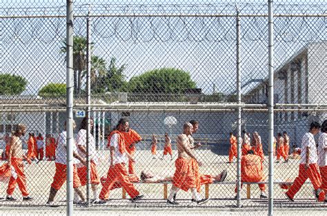 Inmates walk around an exercise yard at the California Institution
